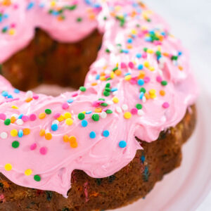 Konfetti-Gugelhupf mit rosa Buttercreme und bunten Konfetti-Streuseln in Nahaufnahme von oben