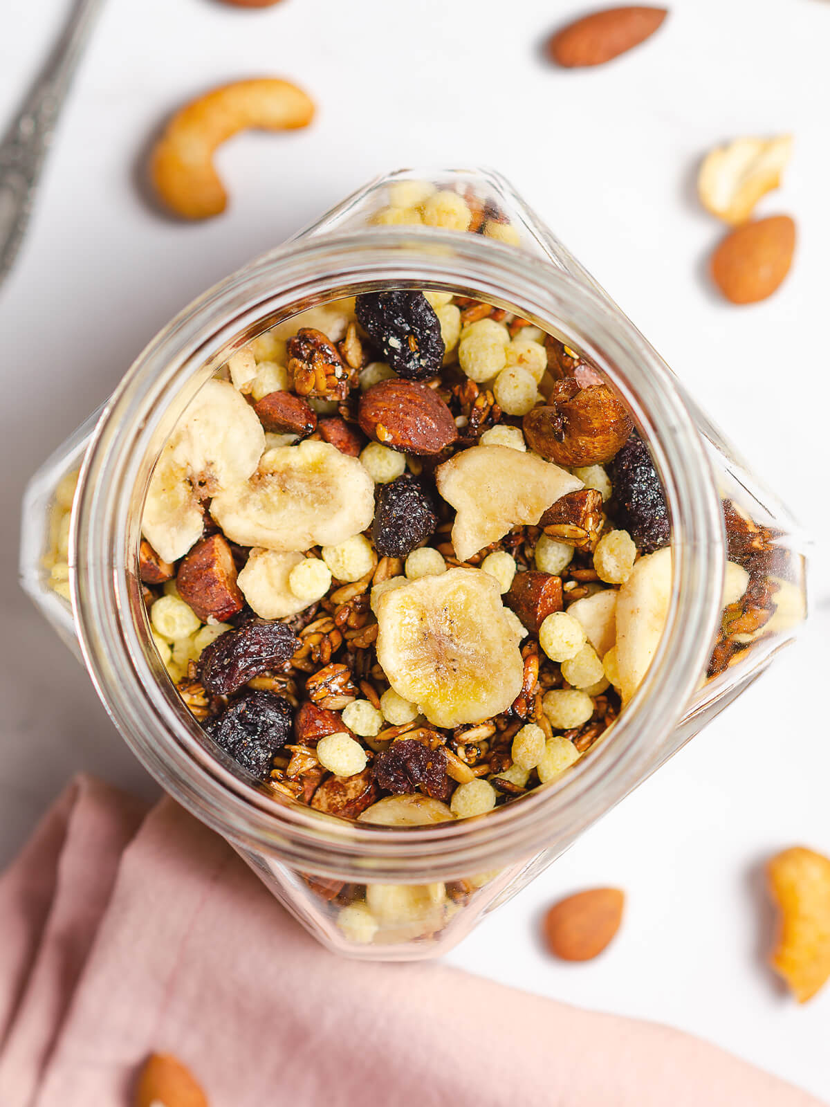 Selbst gemachtes Knusper-Granola mit Bananenchips, Cranberries und Nüssen in einem Glas von oben