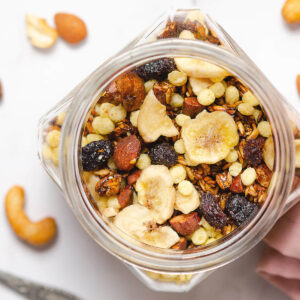 Selbst gemachtes Knusper-Granola mit Bananenchips, Cranberries, Nüssen und Puffreis in einem Glas von oben