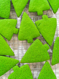 Fertig gebackene grüne Lebkuchen-Tannenbäume in Nahaufnahme auf einem Kuchengitter