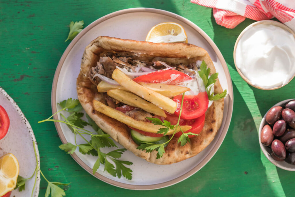 Griechisches Gyros im Pita-Brot mit Tzatziki, Pommes und Salat