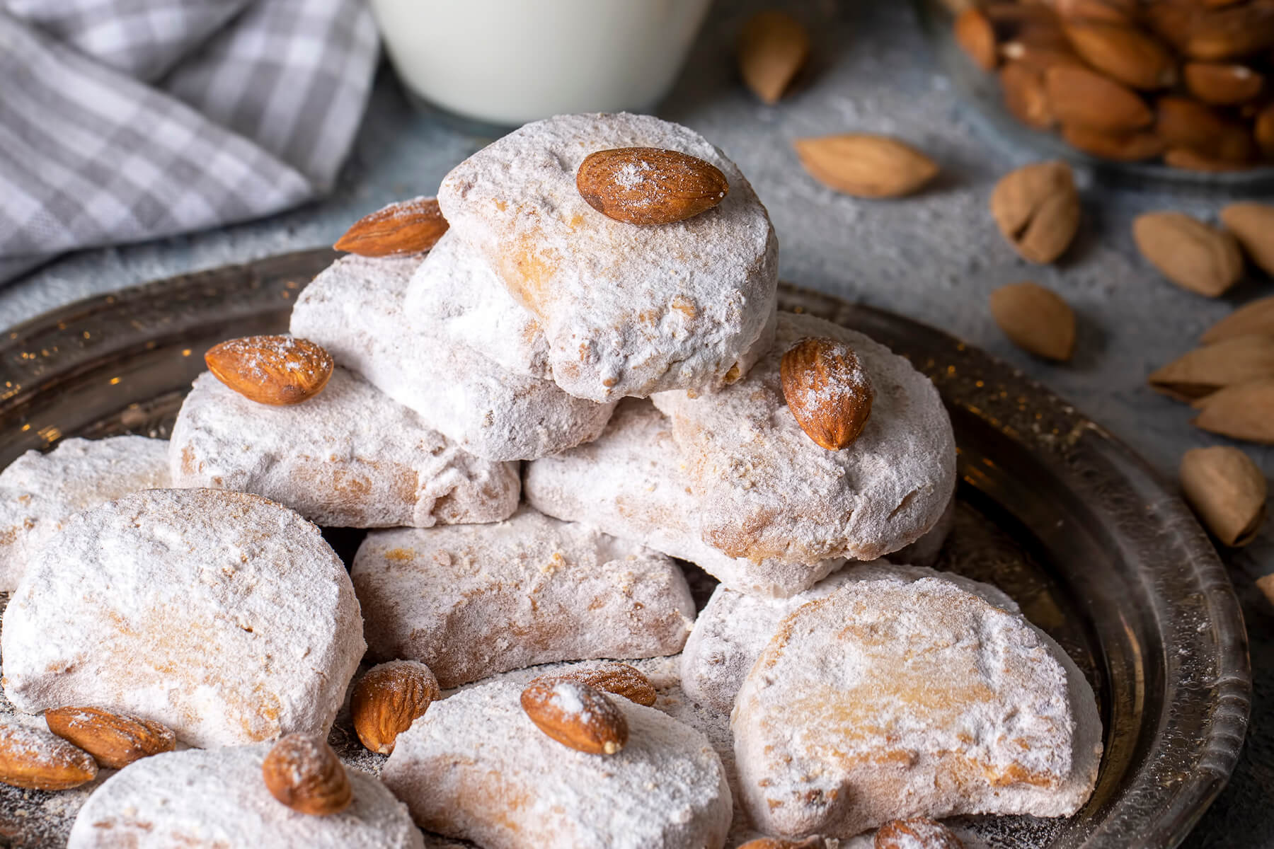 Kavala Cookies auf einer silbernen Platte neben einem Glas Milch und ganzen Mandeln