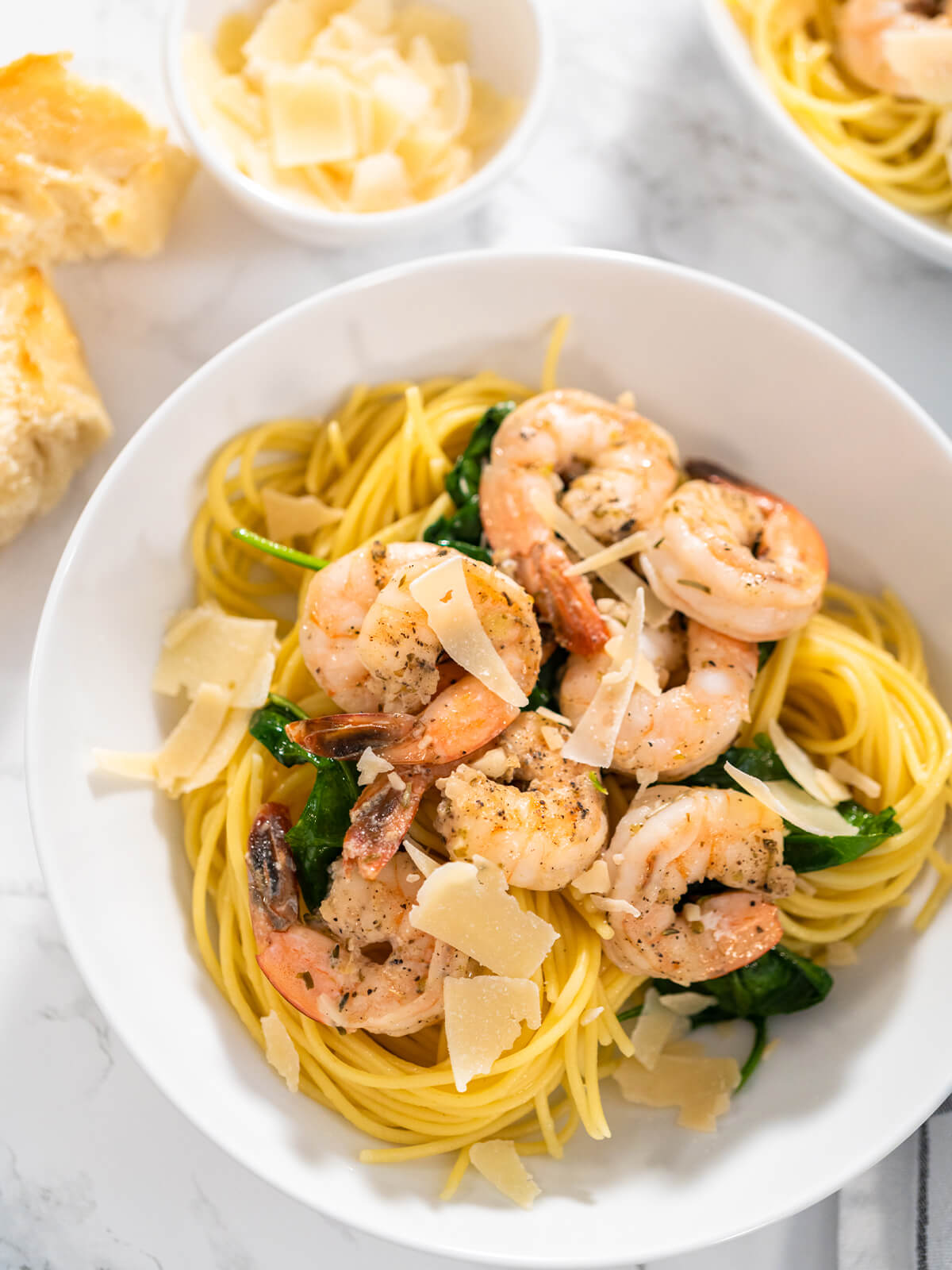 Knoblauch-Garnelen-Spaghetti mit Spinat und Parmesan in einer weißen Schale