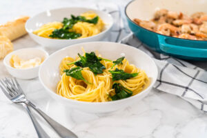 Spaghetti mit angedünstetem Spinat in weißen Schalen angerichtet