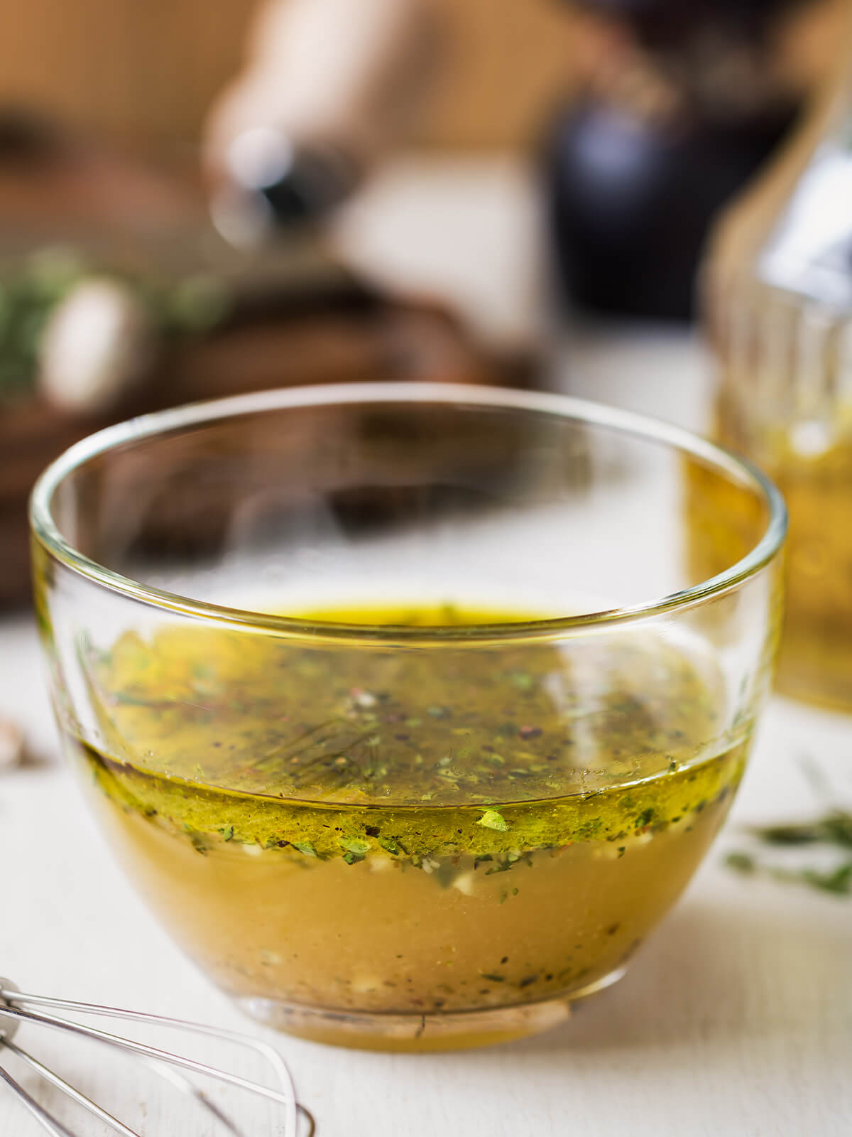 Cremige Kräuter-Senf-Vinaigrette in einer Glasschale mit vielen fein gehackten frischen Kräutern, daneben Thymian