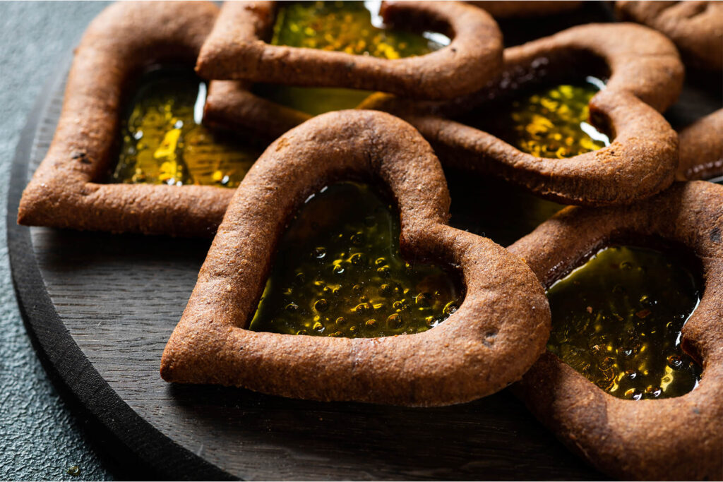 Nahaufnahme der Lebkuchen-Herzen mit glasigem, bernsteinfarbenem Bonbonfenster voller feiner Bläschen