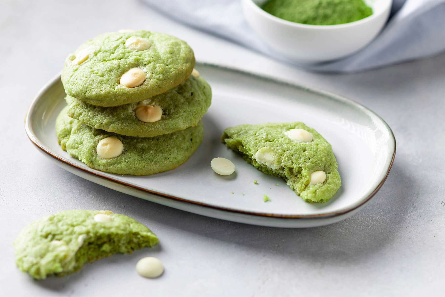 Aufgebrochener grüner Matcha-Cookie, der die weiche Krume und Stückchen weißer Schokolade zeigt
