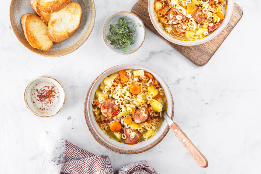 Helle Minestrone mit geräucherter Wurst und Suppennudeln