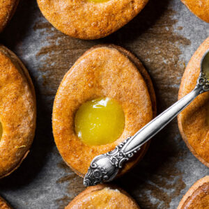 Osterei-Plätzchen mit Lemon Curd und ein Löffel mit Zitronencreme von oben