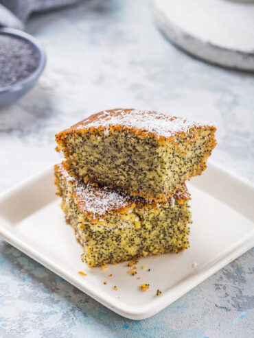 Gestapelte Stücke türkischer Grießkuchen mit Mohn (Revani), oben mit Kokosraspeln bestreut