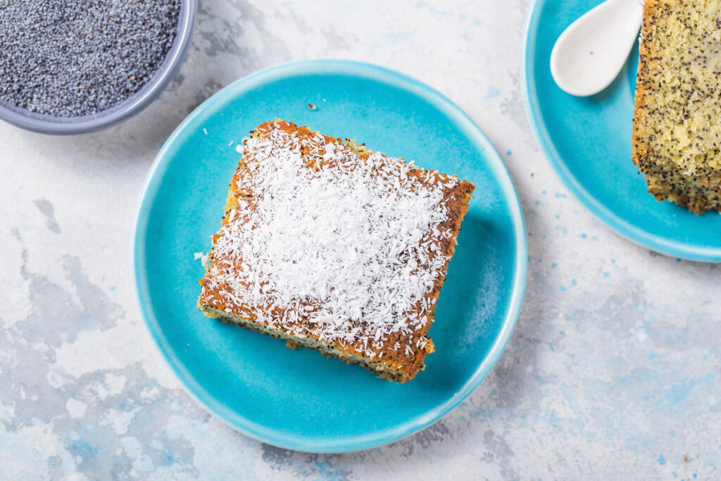 Türkischer Grießkuchen mit Mohn (Revani) von oben, bestreut mit Kokosraspeln, ein Stück auf einem Teller