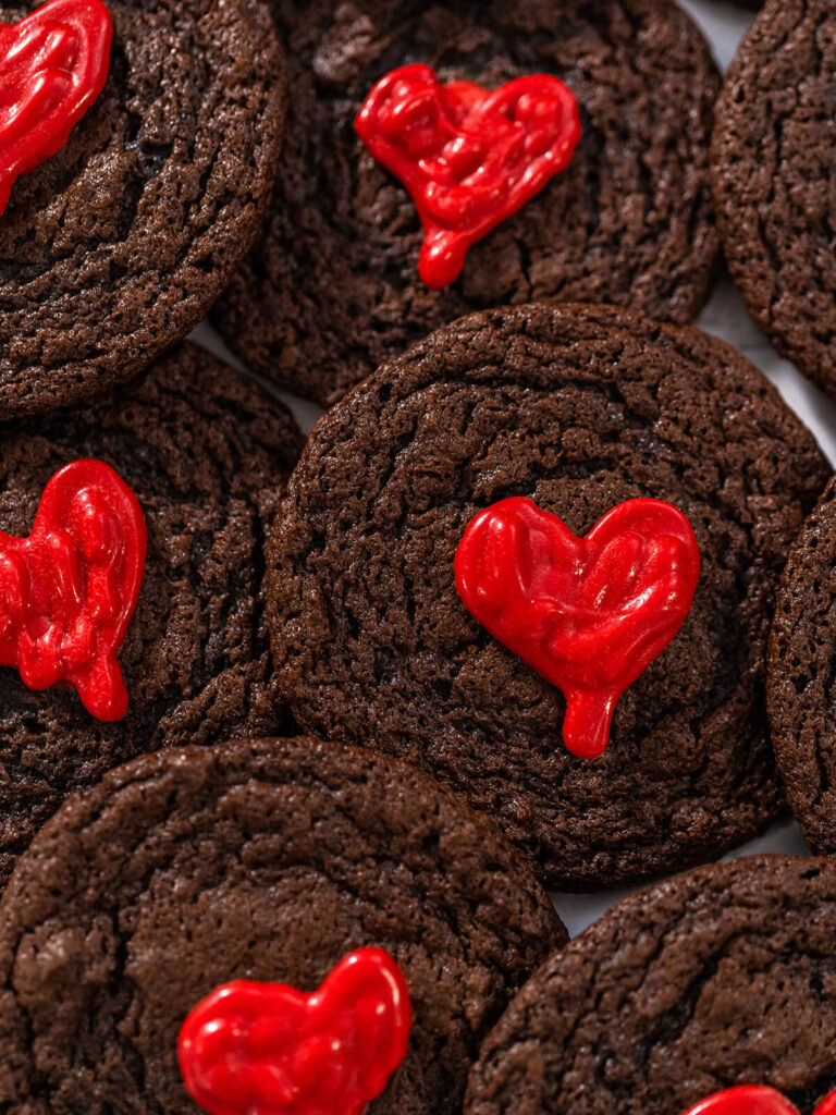 Nahaufnahme von Schokoladen-Cookies mit glänzenden roten Schoko-Herzen