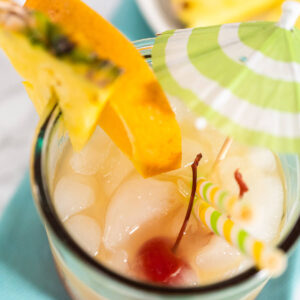Tropischer Sunset-Cocktail mit Farbverlauf von Rot zu Gelb, Crush-Eis und Fruchtdeko von oben