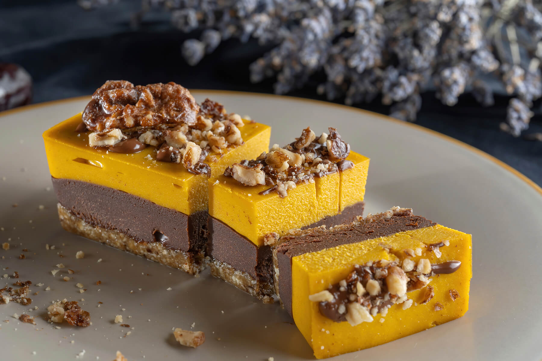 Drei vegane Kürbis-Schoko-Riegel nebeneinander mit deutlich sichtbaren Schichten aus Boden, Schokoladencreme und Kürbisschicht