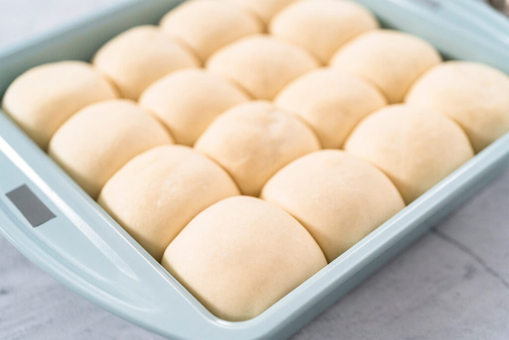 Aufgegangene Teiglinge, die sich in der Form berühren, vor dem Backen