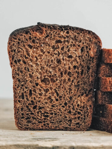 Angeschnittenes dunkles Roggenbrot mit feinporiger brauner Krume und fast schwarzer Kruste