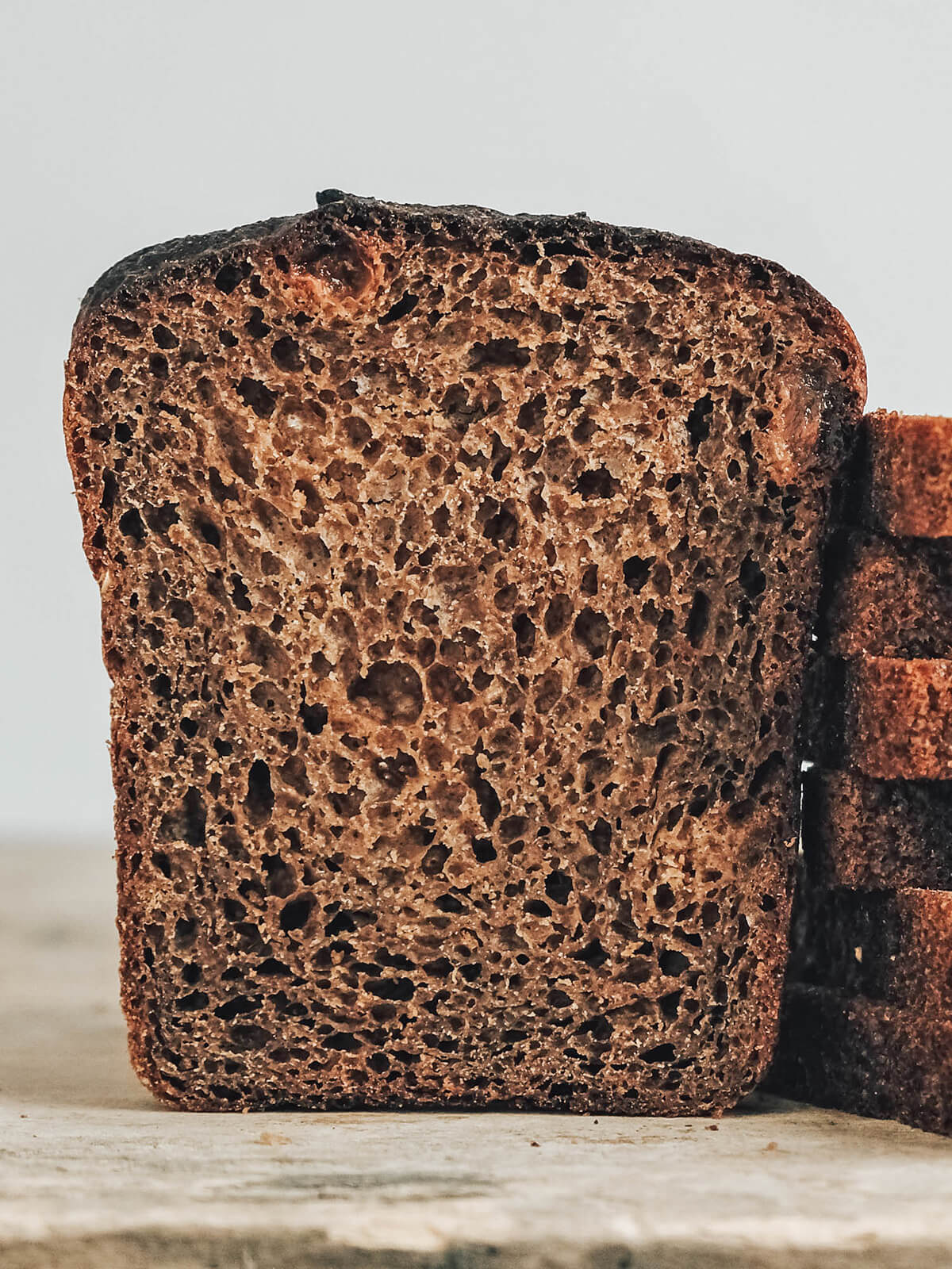 Angeschnittenes dunkles Roggenbrot mit feinporiger brauner Krume und fast schwarzer Kruste