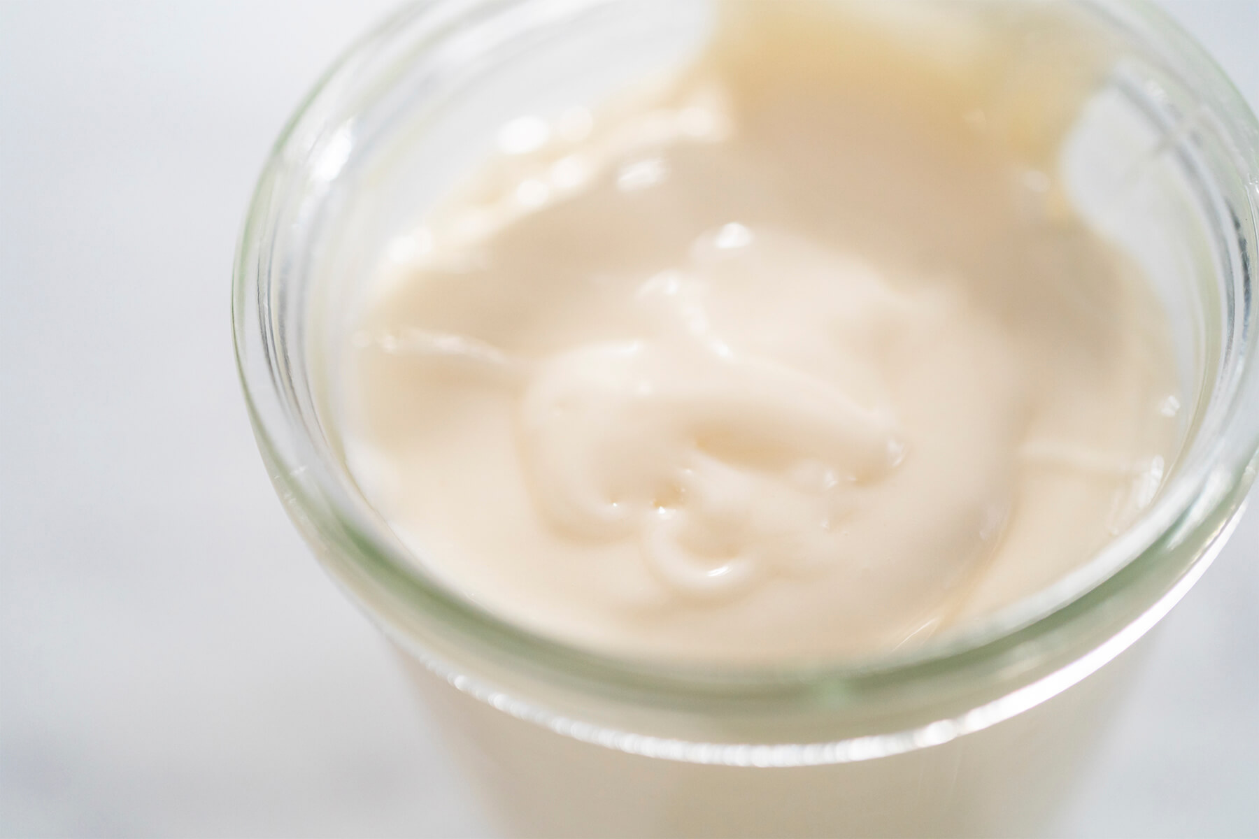 Nahaufnahme der glatten, klümpchenfreien Frischkäse-Glasur im Glas