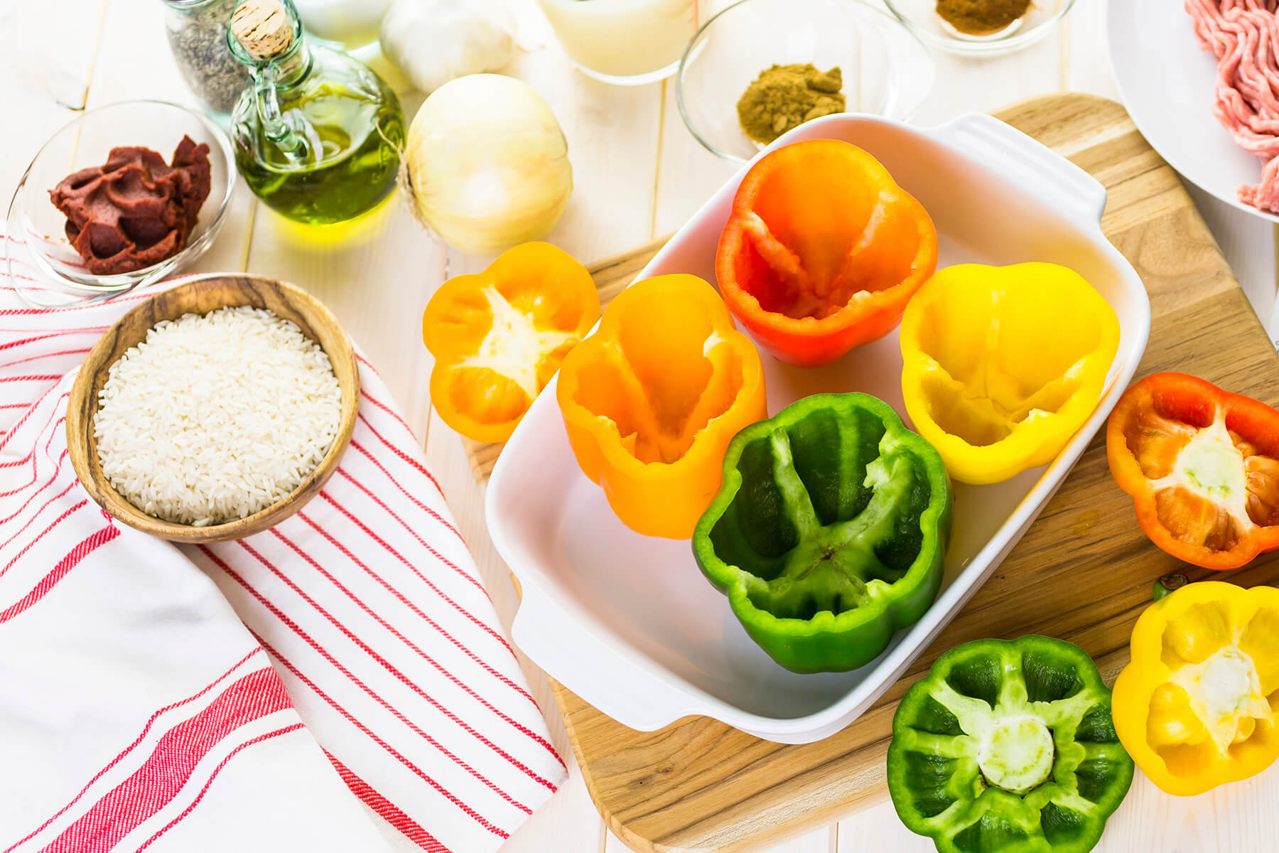 Zutaten für gefüllte Paprika mit Putenhack: ausgehöhlte bunte Paprika, Putenhackfleisch, gekochter Reis, Tomatenmark, Olivenöl, Zwiebel, Knoblauch und Gewürze