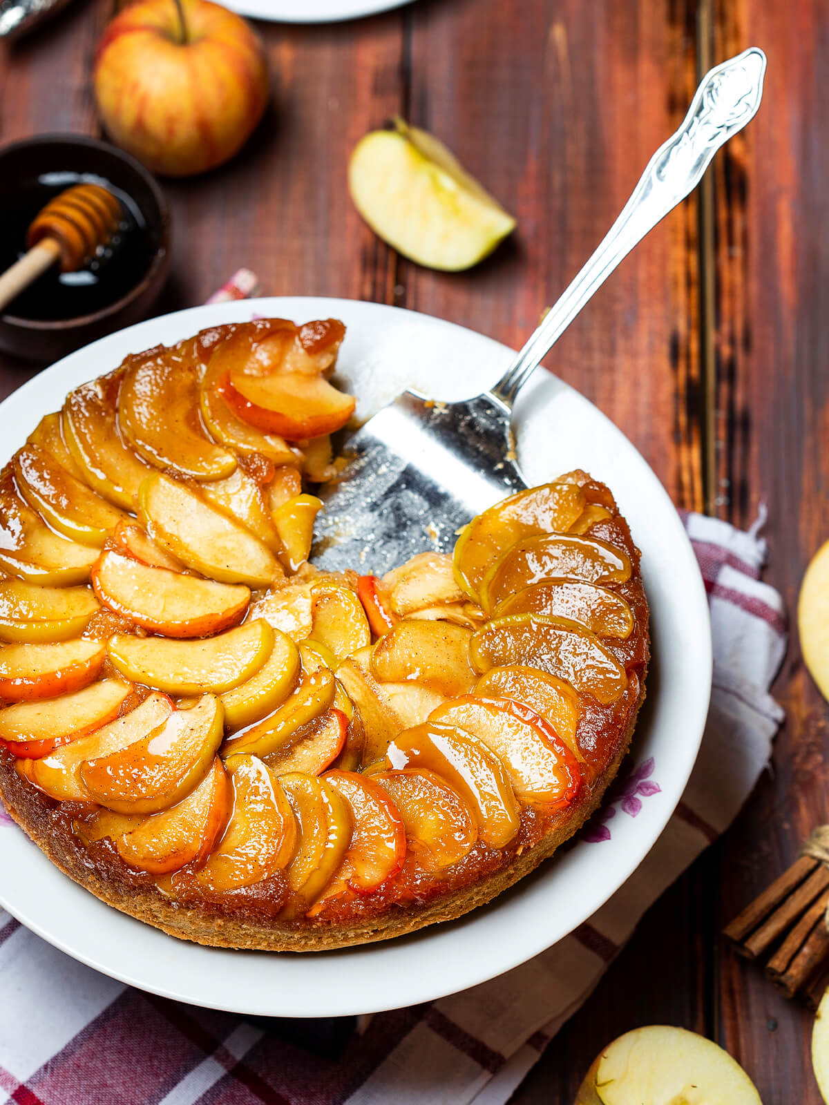 Gestürzter Apfelkuchen mit Honig-Karamell, angeschnitten mit sichtbarem saftigem Kuchenboden