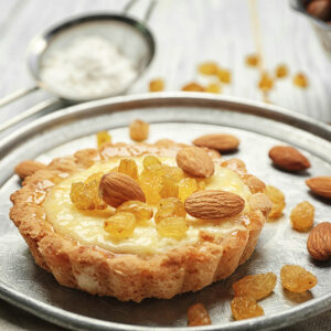 Knusprige Grieß-Tartelette mit Mandeln und goldenen Sultaninen in Nahaufnahme