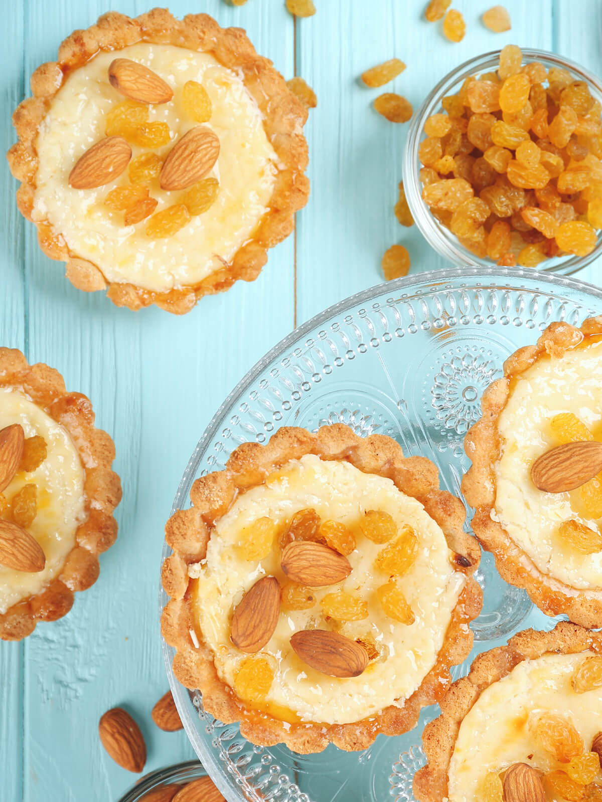 Knusprige Grieß-Tartelettes mit Mandeln und goldenen Sultaninen auf einer Glas-Etagere
