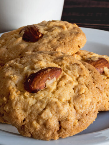 Mürbe Mandel-Cashew-Kekse mit ganzer Mandel auf weißem Teller