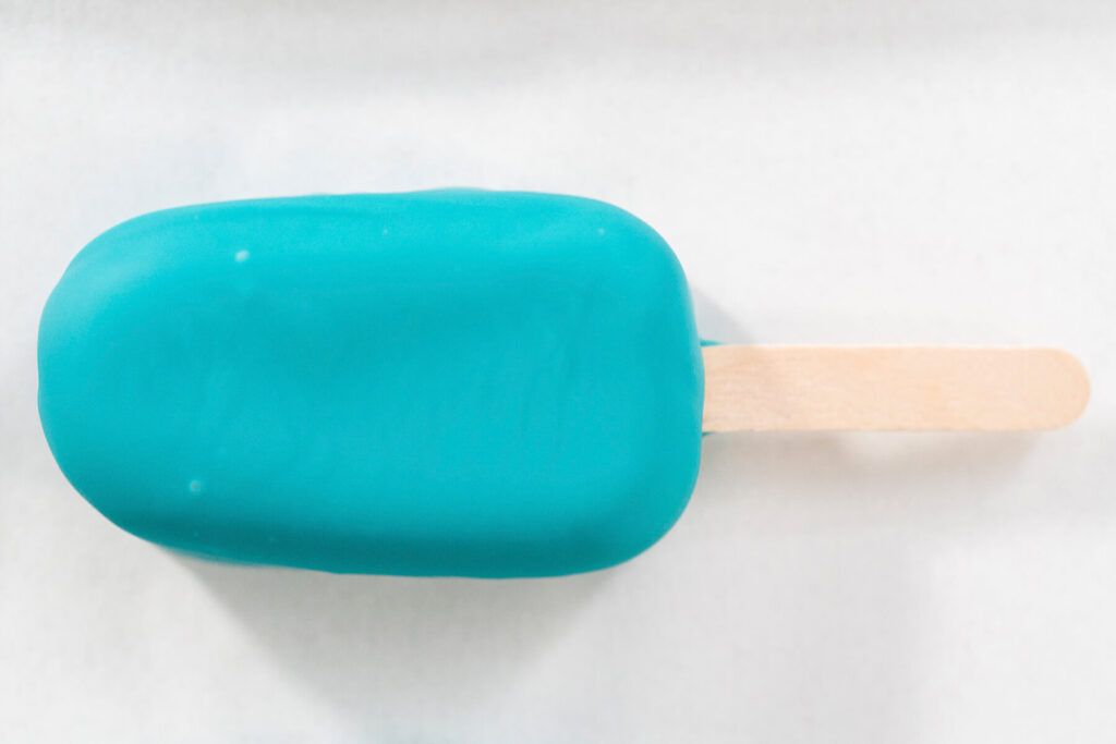 Frisch getauchtes Cakesicle mit glatter türkiser Glasur von oben