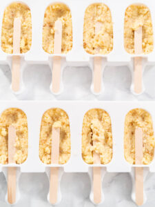 Zwei befüllte Cakesicle-Formen von oben mit eingesetzten Holzstielen