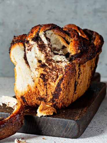 Angeschnittene Mohn-Babka mit heller, faseriger Krume und dunklen Mohnschichten