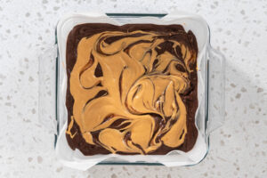 Fertig marmorierte Fudge-Oberfläche mit hellen Erdnussbutter-Bögen in der Glasform