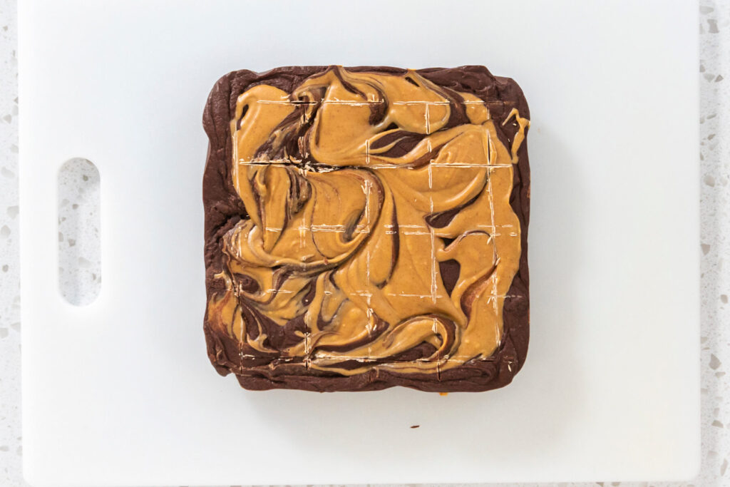 Fudge-Platte mit oberflächlich eingeschnittenem Raster aus 16 Feldern auf einem weißen Brett