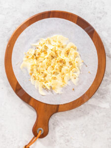 In Wellen gestrichene Butter, mit Olivenöl beträufelt und mit gerösteten Walnüssen bestreut