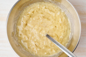 Helle, schaumige Masse aus Bananenmus, Eiern, Zucker und Öl in der Rührschüssel