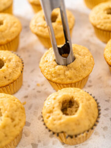 Apfelausstecher sticht die Mitte aus einem ausgekühlten Karamell-Cupcake