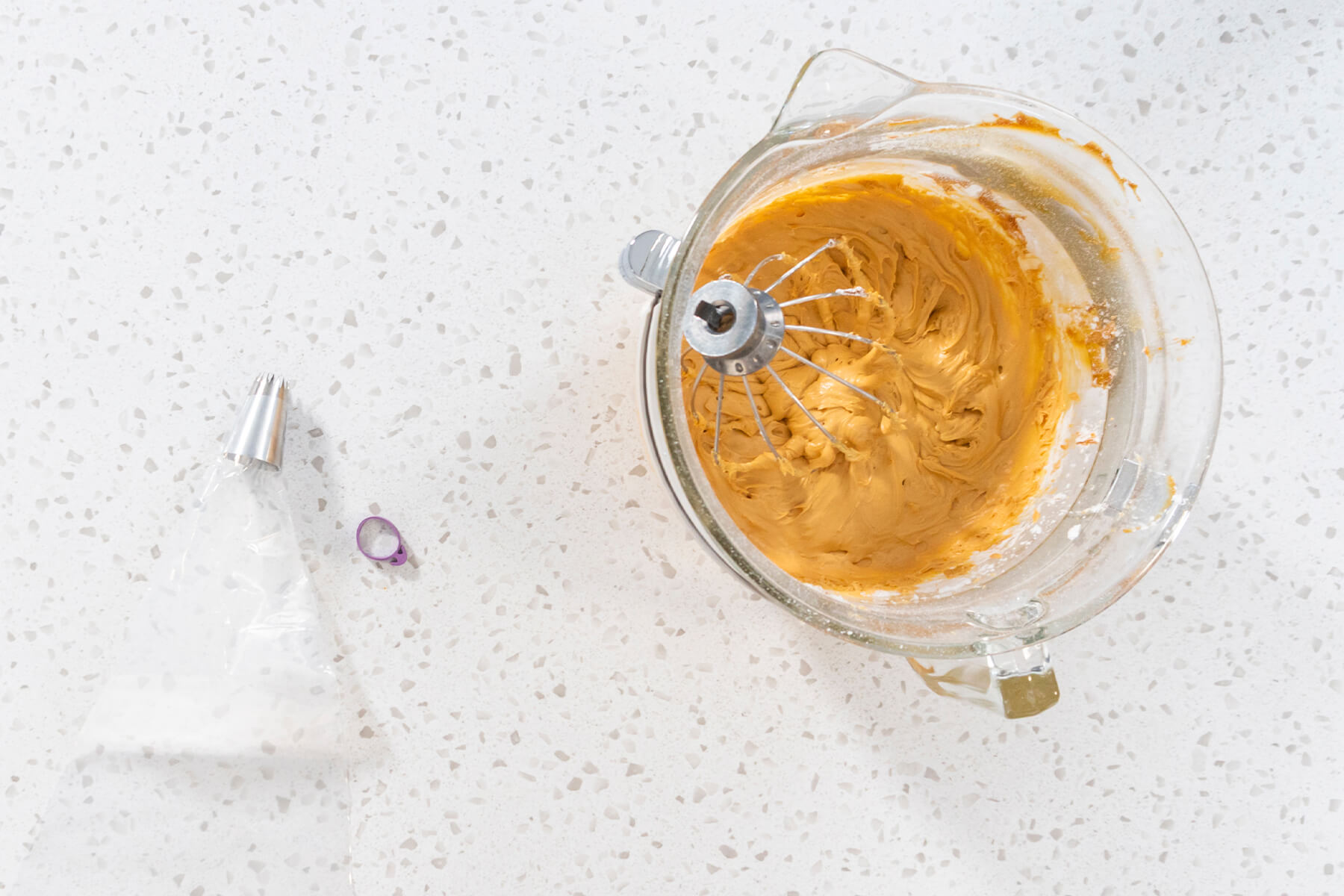 Rührschüssel mit Dulce-de-Leche-Buttercreme und daneben ein leerer Spritzbeutel mit Sterntülle