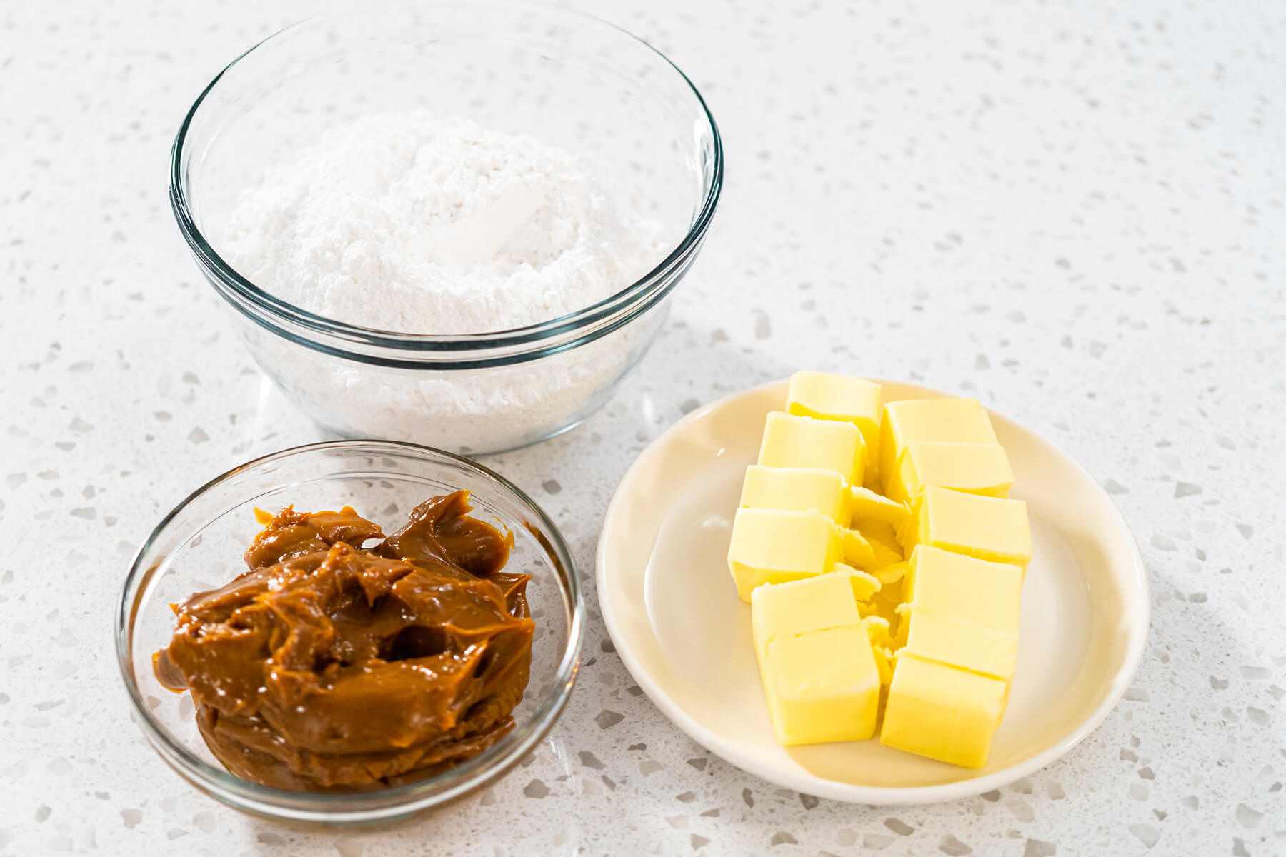 Zutaten für die Dulce-de-Leche-Buttercreme: Puderzucker, Dulce de Leche und Butterwürfel