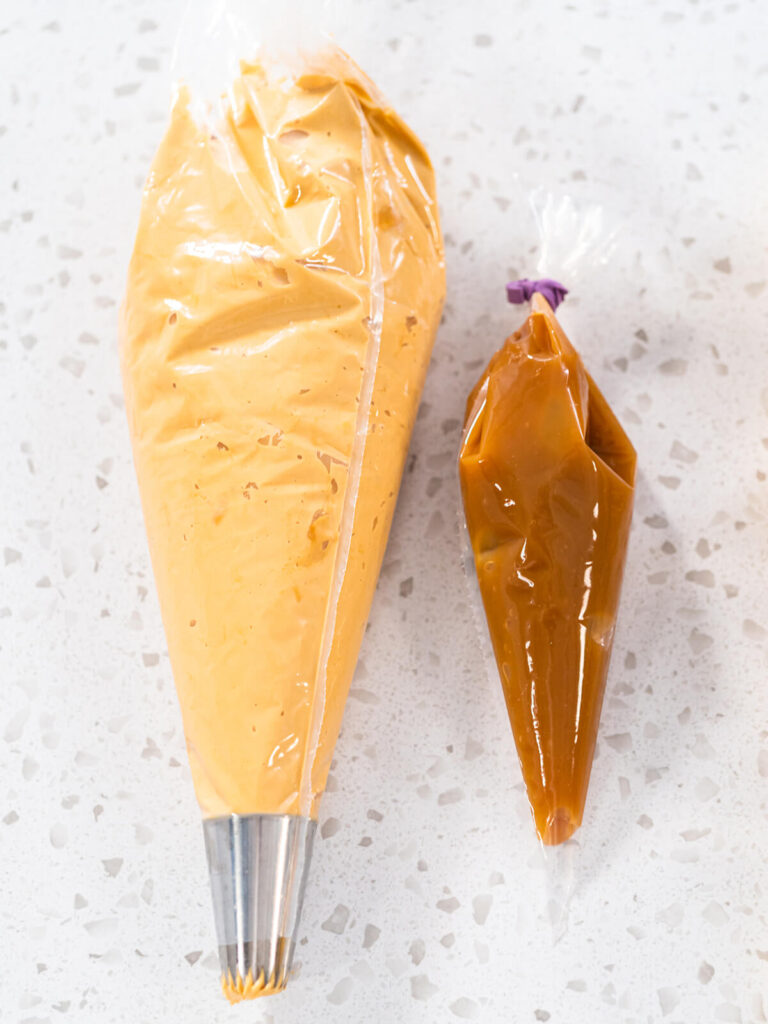Zwei Spritzbeutel nebeneinander: Dulce-de-Leche-Buttercreme mit Sterntülle und dickflüssige Karamellsauce