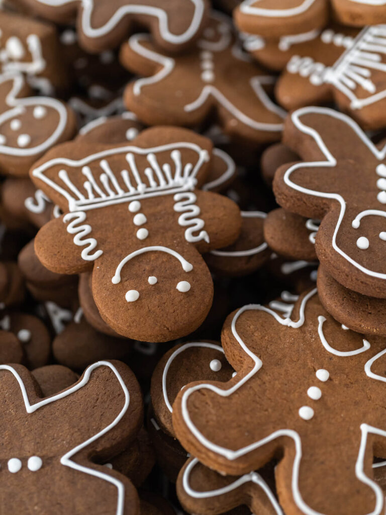 Ausgekühlte Lebkuchen-Männchen und -Mädchen, mit weißen Konturen aus Eiweißglasur verziert