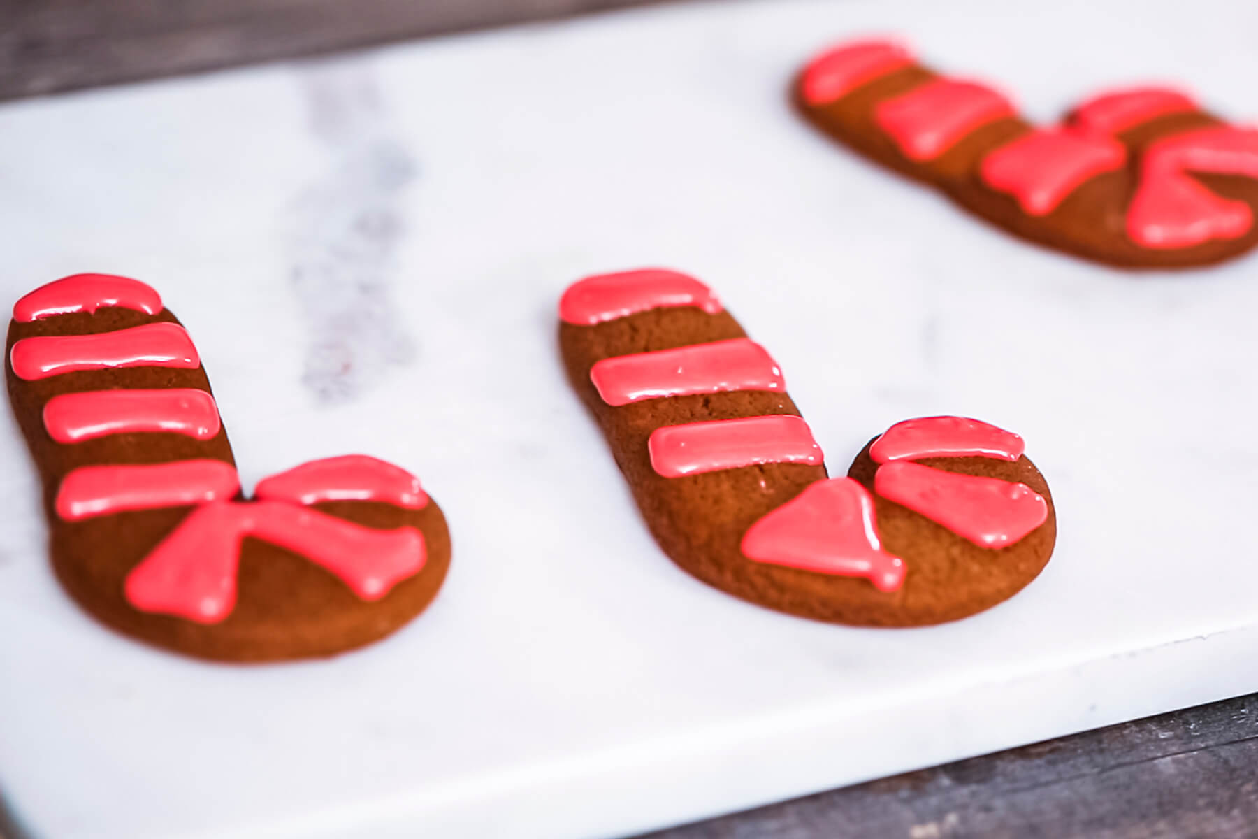 Lebkuchen-Zuckerstangen mit roten Glasurstreifen, zwischen denen der Keks noch frei liegt