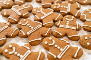 Nahaufnahme fertig verzierter Lebkuchen-Männchen mit weißen Linien, Punkten und Gesichtern
