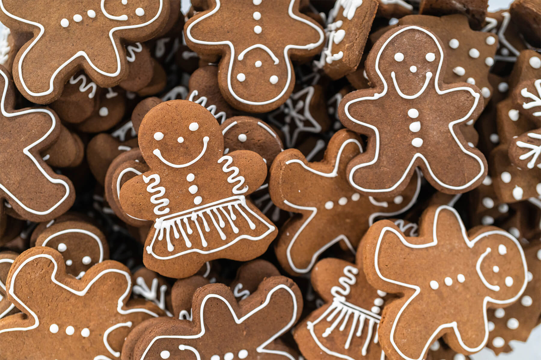 Gestapelte Lebkuchen-Männchen und -Mädchen mit vollständig getrockneter weißer Eiweißglasur