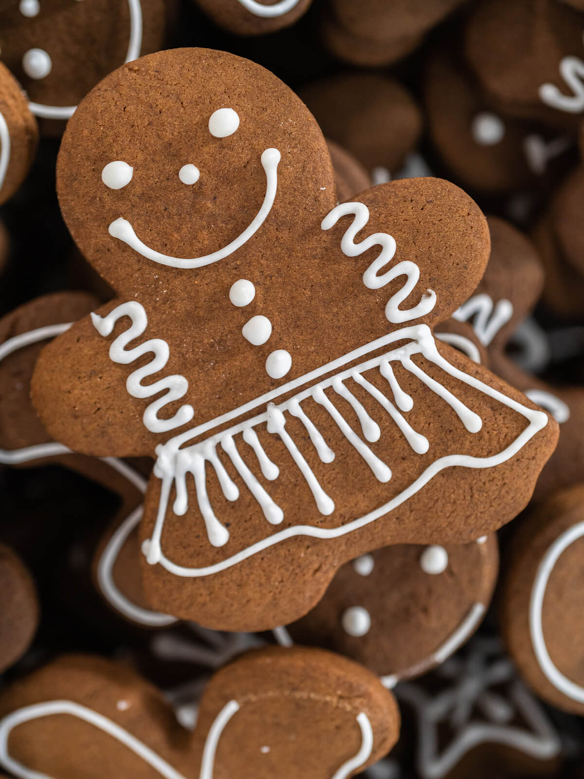 Nahaufnahme eines Lebkuchen-Mädchens mit weißer Konturglasur, Rüschenrock und feinen Punkten