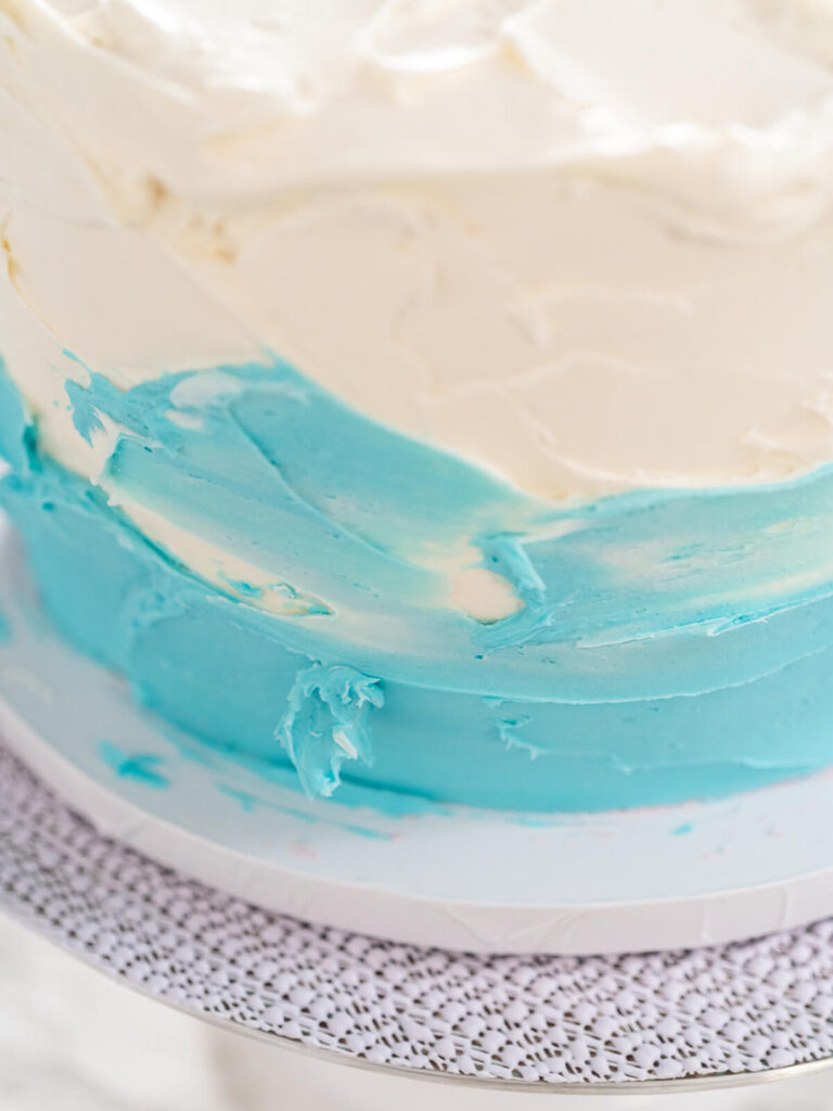 Torte mit weißem Deckel und blauem unterem Bereich, die Grenzlinie zwischen den Farben wird mit der Teigkarte zu einem weichen Verlauf verwischt