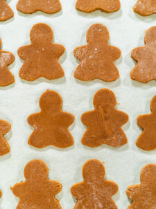 Ausgestochene rohe Lebkuchen-Figuren mit sauberen Kanten auf einem Bogen Backpapier