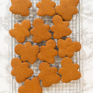 Gebackene Lebkuchen-Figuren auf einem Abkühlgitter über heller Marmorfläche
