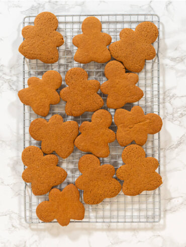 Gebackene Lebkuchen-Figuren auf einem Abkühlgitter über heller Marmorfläche