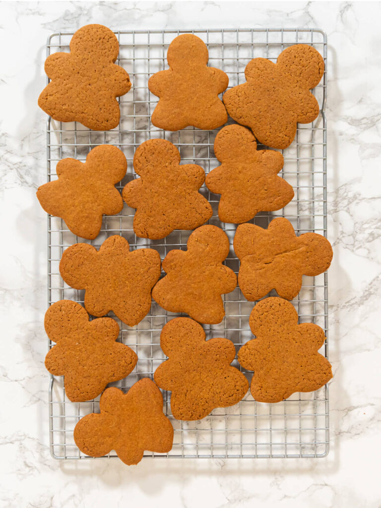 Gebackene Lebkuchen-Figuren auf einem Abkühlgitter über heller Marmorfläche