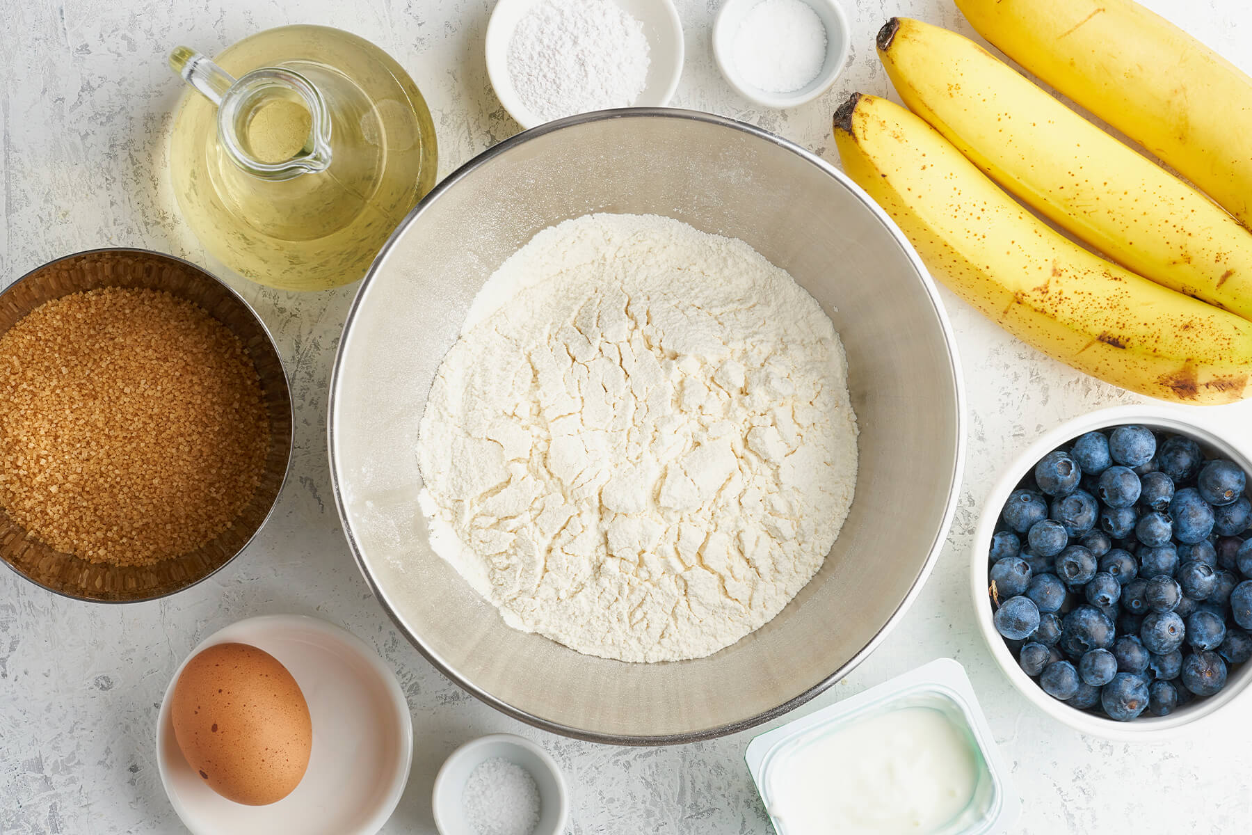 Zutaten für Bananenbrot mit Heidelbeeren - Bananen, Heidelbeeren, Mehl, Rohrohrzucker, Öl, Ei, Joghurt, Backpulver und Salz