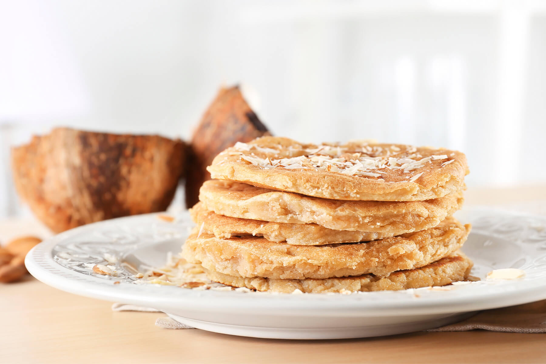 Kokosmehl-Pancakes von der Seite mit dichter Krume und unregelmäßigen, eingerissenen Rändern